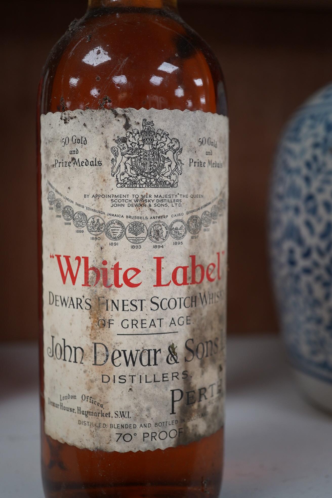 John Dewar & Sons Ltd. White Label, Finest Scotch Whisky Of Great Age, By Appointment to Her Majesty The Queen. Condition - label stained, bottle dirty, sealed